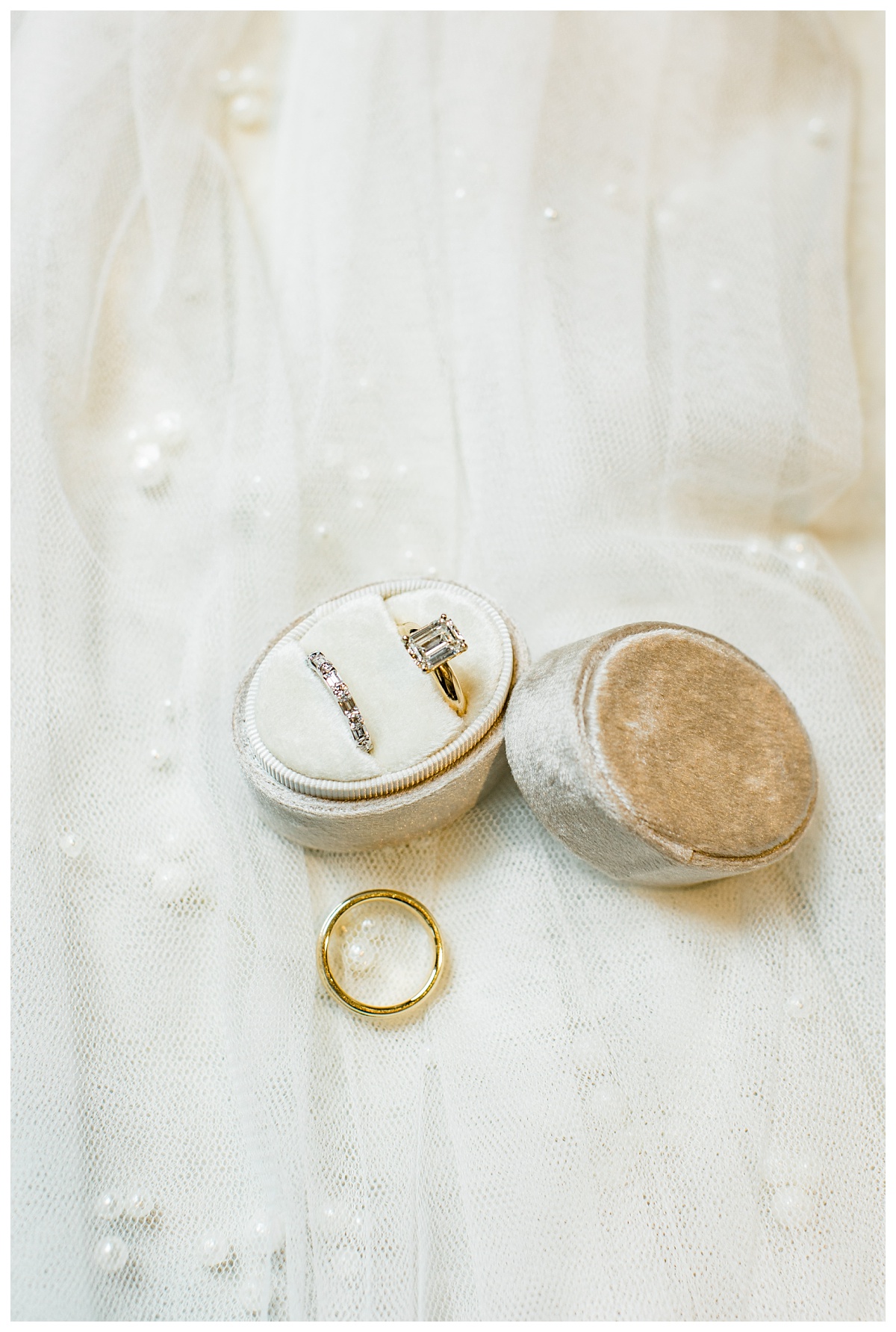 Wedding rings inside ring box on pearl veil